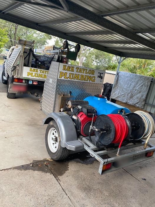 The K&K Taylor Plumbing ute and trailer jetter parked under a carport