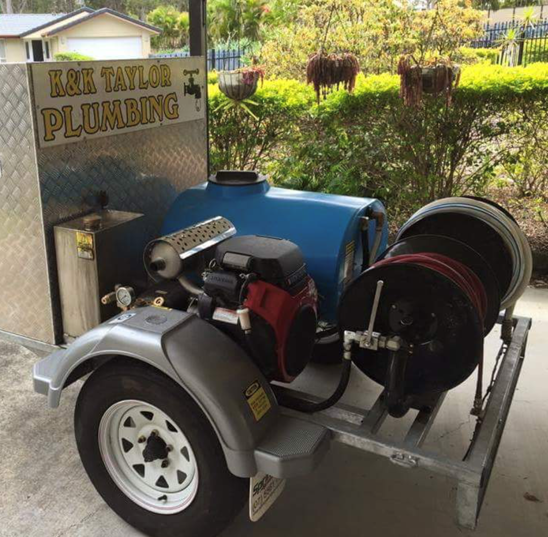 The K&K Taylor Plumbing trailer jetter with its blue water tank and hose reels